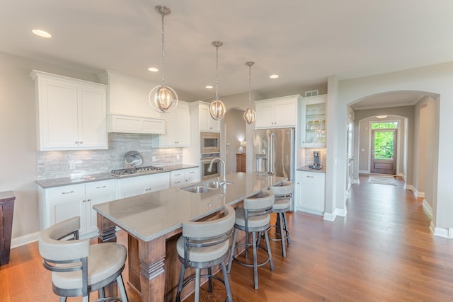 11328 Blazingstar Ln, Lake Elmo, MN 55042 - kitchen featuring a sink, appliances with stainless steel finishes, arched walkways, a kitchen bar, and recessed lighting