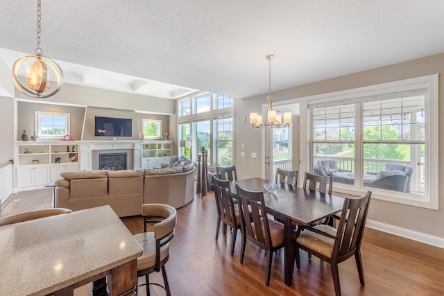11328 Blazingstar Ln, Lake Elmo, MN 55042 - dining room featuring a chandelier, dark wood-style flooring, healthy amount of natural light, and a textured ceiling