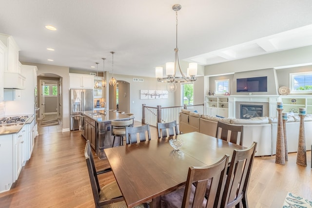 11328 Blazingstar Ln, Lake Elmo, MN 55042 - dining space with arched walkways, light wood finished floors, recessed lighting, a chandelier, and baseboards