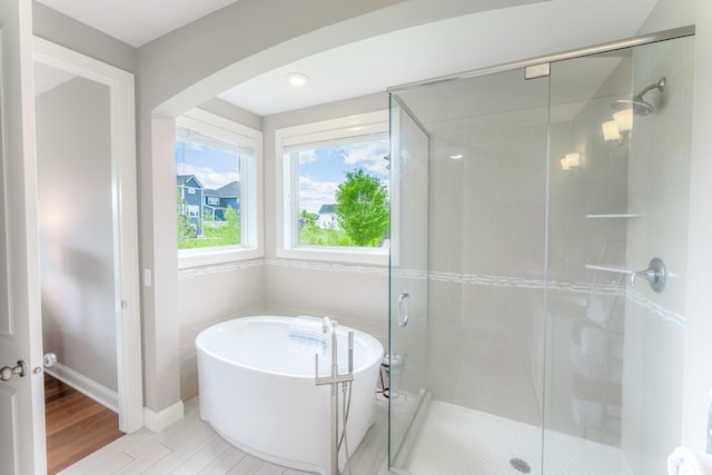 11328 Blazingstar Ln, Lake Elmo, MN 55042 - full bath with a stall shower, a freestanding bath, wood finished floors, and baseboards