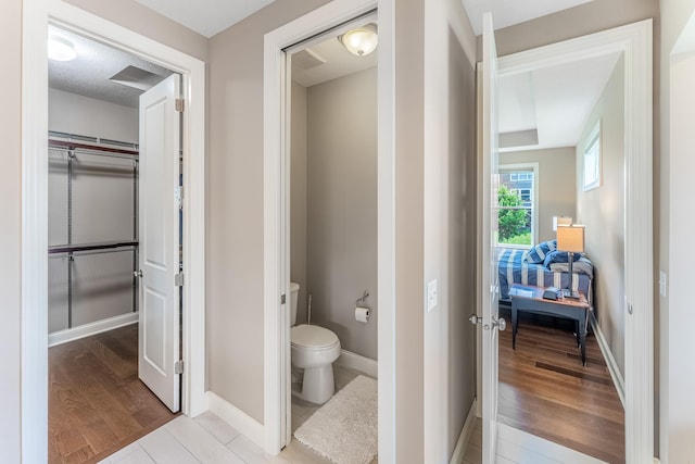 11328 Blazingstar Ln, Lake Elmo, MN 55042 - bathroom featuring toilet, baseboards, and wood finished floors