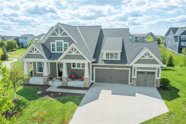 11328 Blazingstar Ln, Lake Elmo, MN 55042 - craftsman inspired home with stone siding, a porch, a shingled roof, a front yard, and driveway