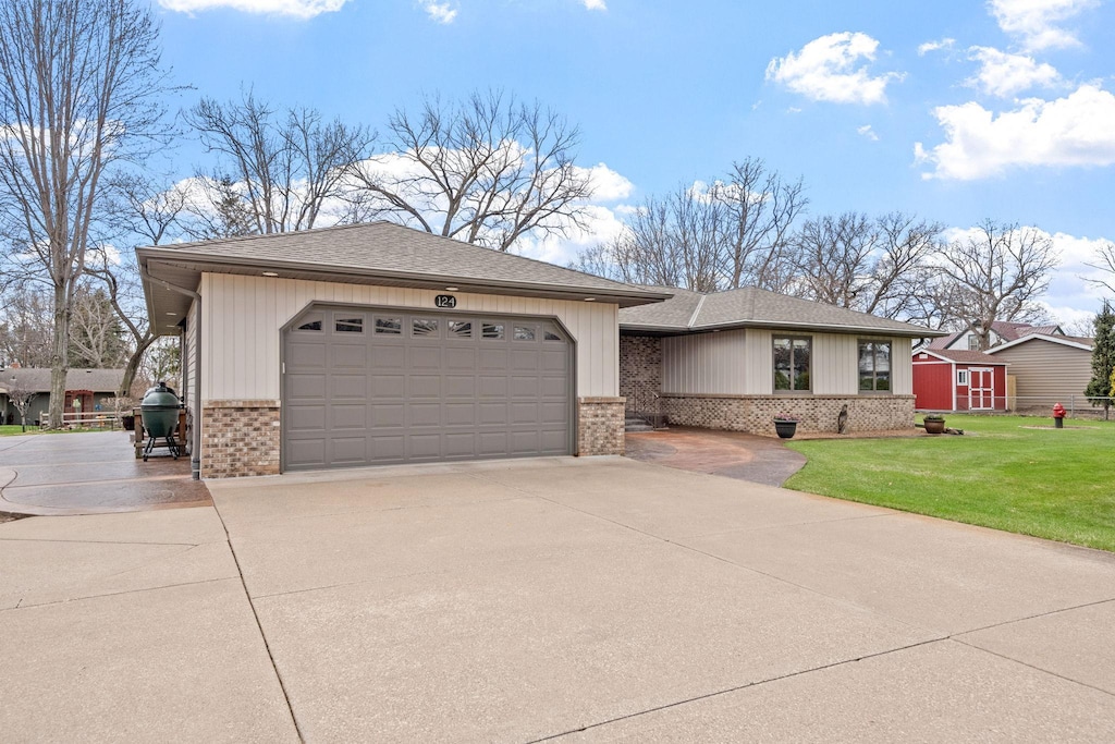 124 Twin Lake Blvd, Little Canada, MN 55127 - view of front of house with concrete driveway, an attached garage, a front yard, brick siding, and roof with shingles