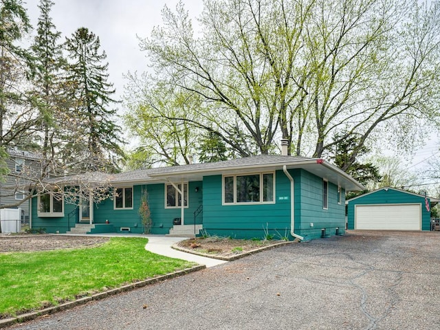 single story home featuring an outdoor structure, a front yard, and a detached garage
