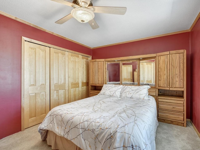 carpeted bedroom with ornamental molding, a closet, and a ceiling fan