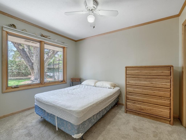 bedroom with carpet, baseboards, ceiling fan, and crown molding