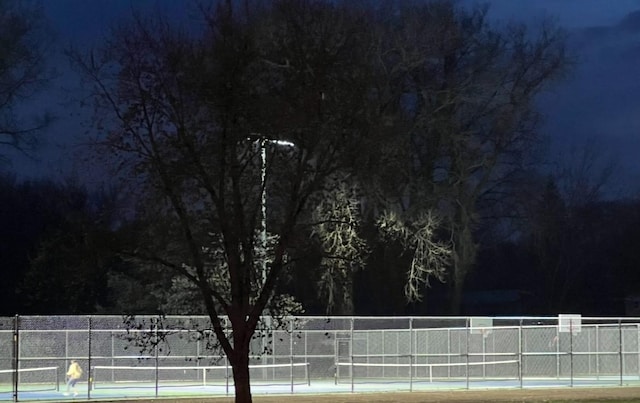 view of tennis court featuring fence