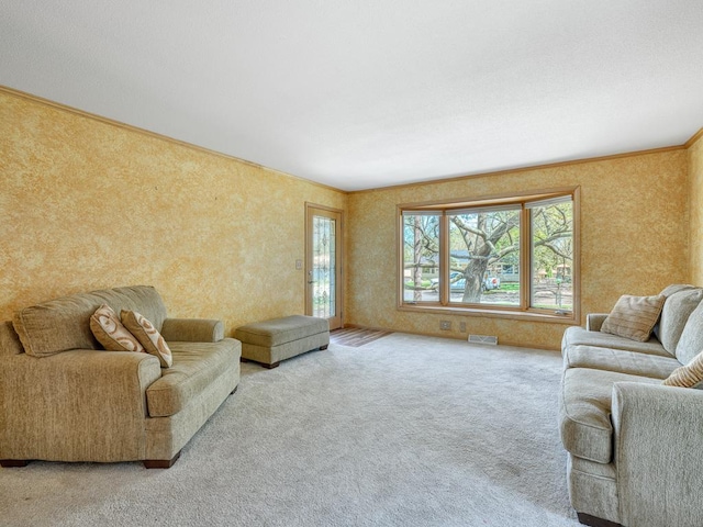 carpeted living area featuring crown molding and visible vents