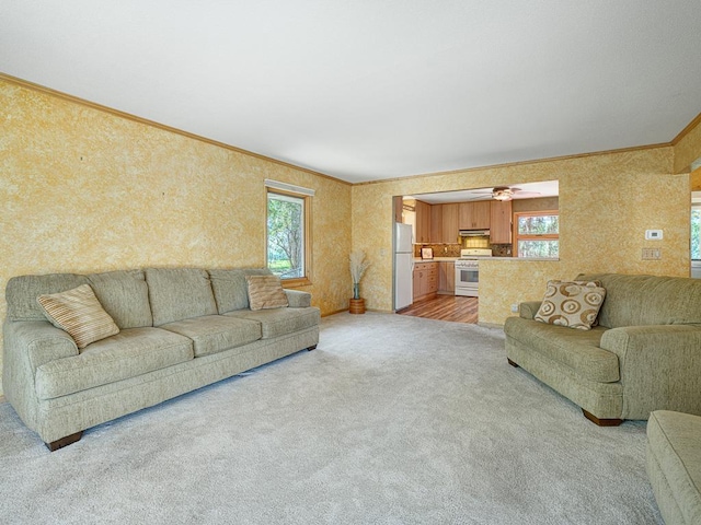 living room featuring ornamental molding, plenty of natural light, and light colored carpet