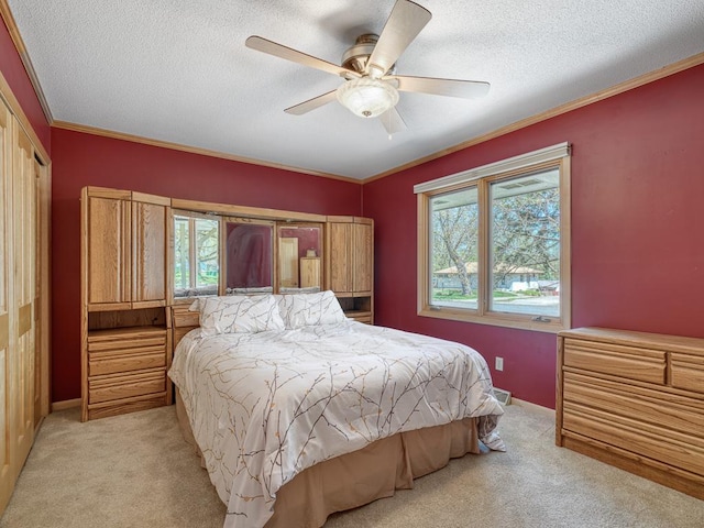 bedroom featuring ceiling fan, a textured ceiling, light carpet, and ornamental molding