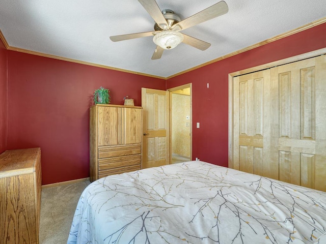 bedroom featuring a closet, ornamental molding, carpet flooring, a ceiling fan, and baseboards