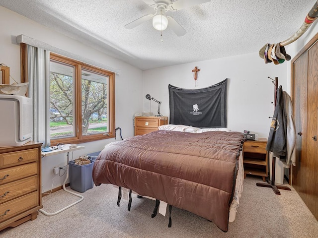 bedroom with a textured ceiling, carpet floors, and a ceiling fan