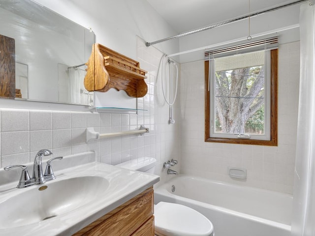 full bathroom featuring toilet, tile walls, backsplash, vanity, and shower / bathing tub combination