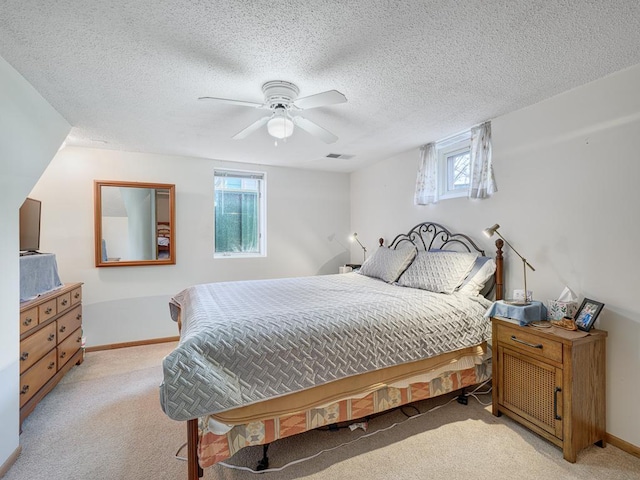 bedroom with light colored carpet, visible vents, baseboards, and ceiling fan