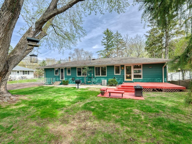 rear view of property with a yard and a deck