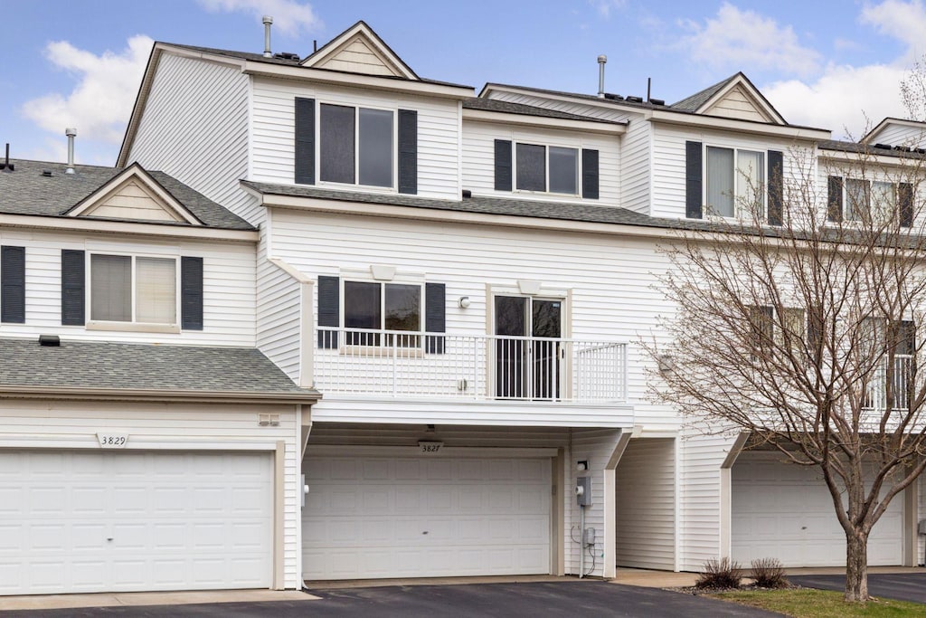 3827 Abercrombie Ln, Stillwater, MN 55082 - view of property featuring a garage, driveway, a shingled roof, and a balcony