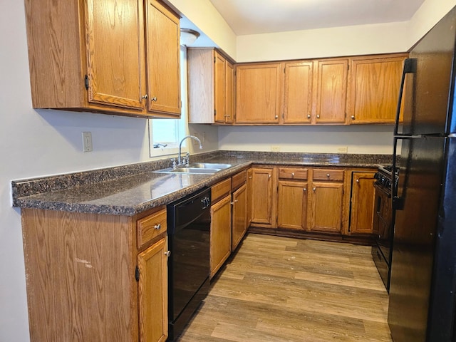 kitchen with black appliances, brown cabinets, and a sink