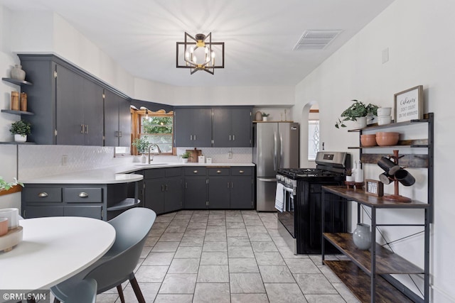 674 Wheelock Pkwy W, Saint Paul, MN 55117 - kitchen with stainless steel appliances, open shelves, arched walkways, tasteful backsplash, and light countertops