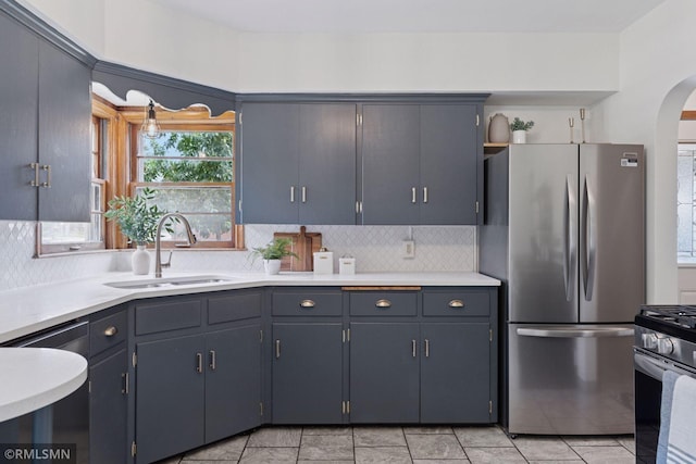 674 Wheelock Pkwy W, Saint Paul, MN 55117 - kitchen featuring stainless steel appliances, arched walkways, decorative backsplash, light countertops, and open shelves