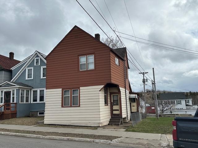 traditional-style home featuring entry steps and a chimney