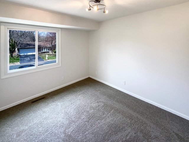 unfurnished room featuring dark carpet, baseboards, and visible vents