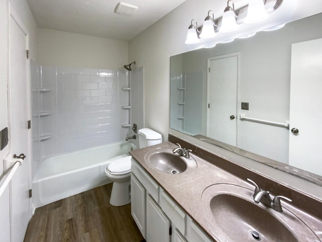 bathroom featuring washtub / shower combination, wood finished floors, toilet, and a sink
