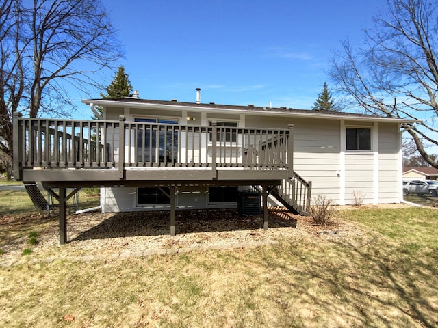 rear view of house with a wooden deck, central air condition unit, a lawn, and stairway