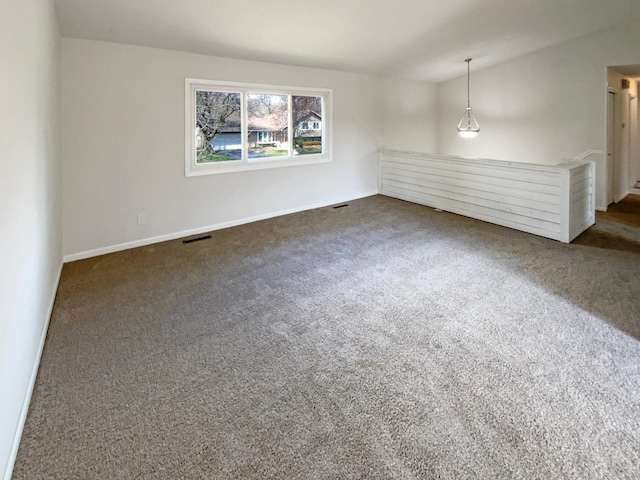 spare room with baseboards, dark colored carpet, and visible vents