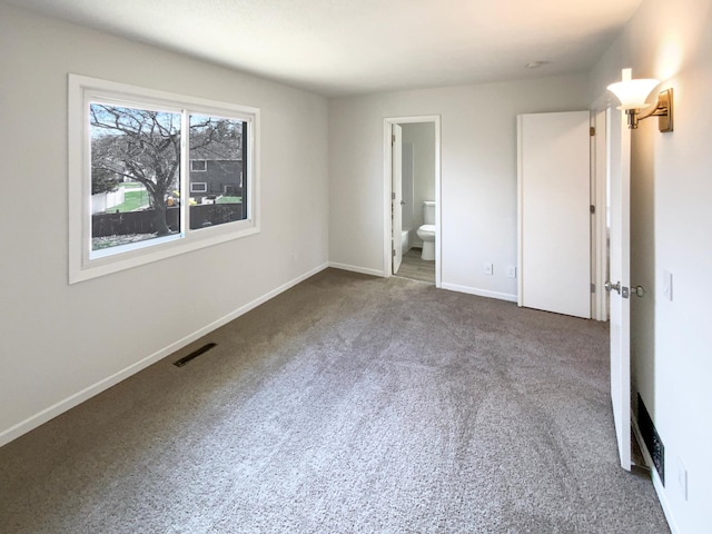 unfurnished bedroom featuring carpet floors, visible vents, baseboards, and connected bathroom