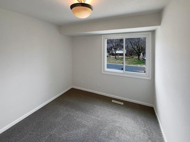 unfurnished room featuring dark carpet, visible vents, and baseboards