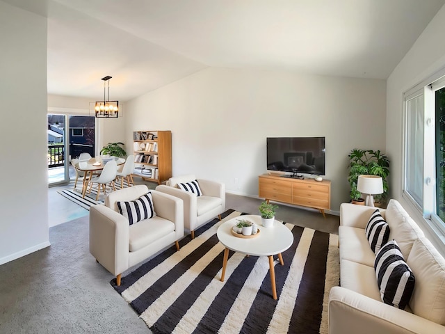 carpeted living area with lofted ceiling, baseboards, and an inviting chandelier