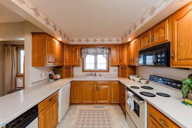 kitchen featuring light floors, light countertops, white appliances, and a sink