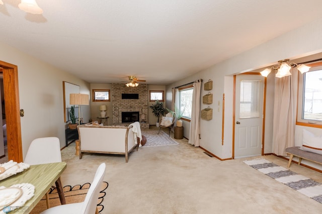 living room featuring visible vents, light carpet, baseboards, a fireplace, and ceiling fan