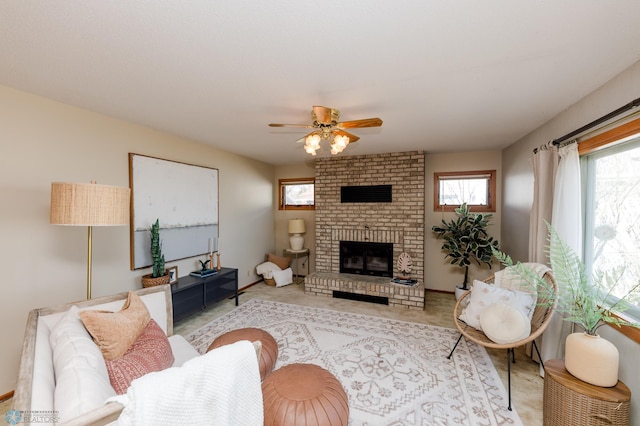 living area with a ceiling fan, a brick fireplace, and a wealth of natural light