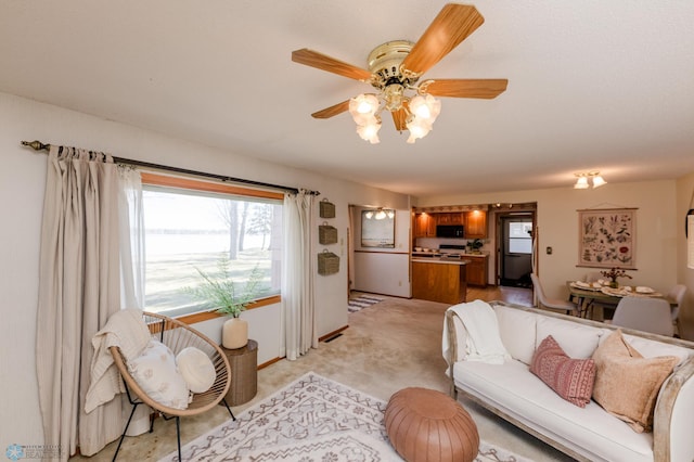 living room featuring a ceiling fan and light colored carpet