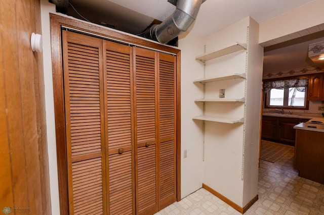 room details with baseboards, tile patterned floors, and a sink