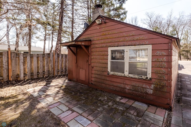 view of property exterior with a chimney, fence, and a patio area