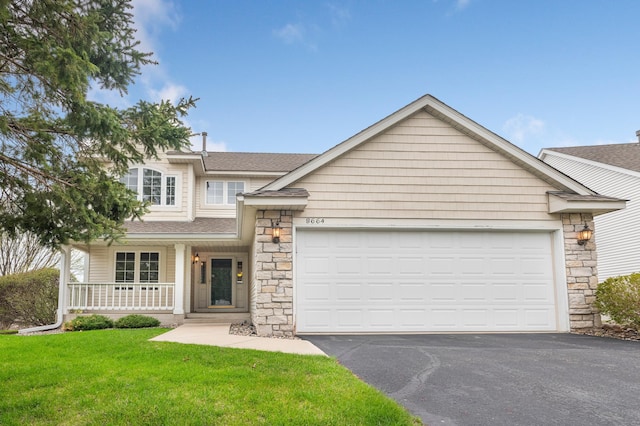 view of front of property featuring a porch, aphalt driveway, stone siding, a garage, and a front lawn