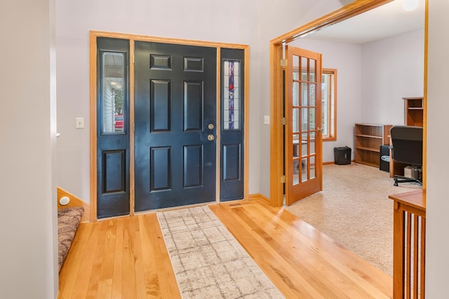 entryway with wood finished floors, french doors, and baseboards