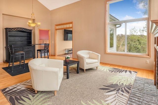living room featuring baseboards, a notable chandelier, high vaulted ceiling, and wood finished floors