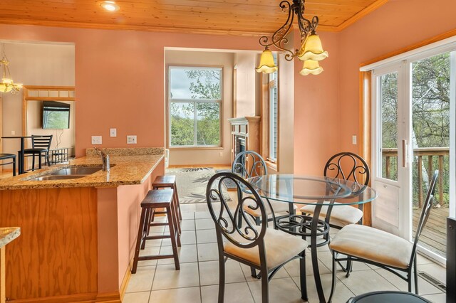 dining space featuring light tile patterned floors, a notable chandelier, crown molding, baseboards, and wooden ceiling