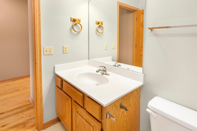 bathroom featuring vanity, toilet, and wood finished floors