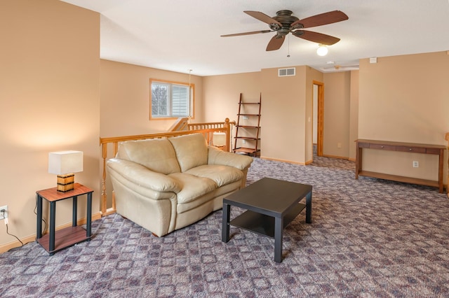 living room featuring carpet flooring, visible vents, baseboards, and ceiling fan