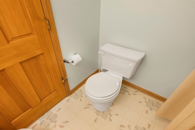 bathroom with baseboards and toilet