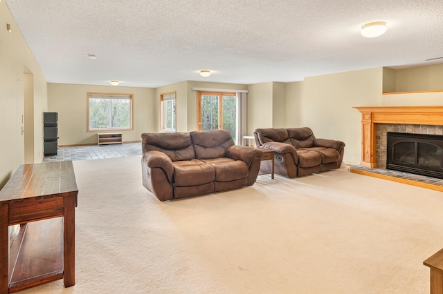 living room featuring a textured ceiling, carpet flooring, and a tiled fireplace