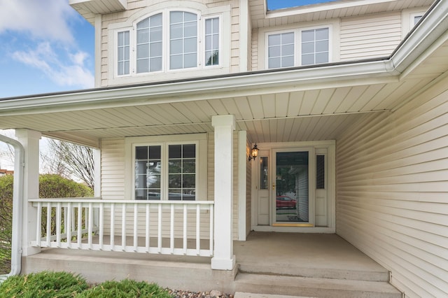 view of exterior entry featuring covered porch