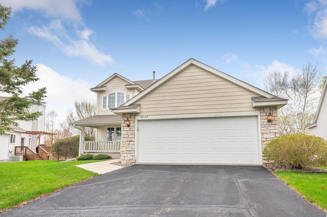 view of front of home with stone siding, an attached garage, cooling unit, a front yard, and driveway