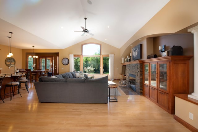 26 Deerwood Ct, North Mankato, MN 56003 - living room with a fireplace, light wood finished floors, ceiling fan, high vaulted ceiling, and a chandelier