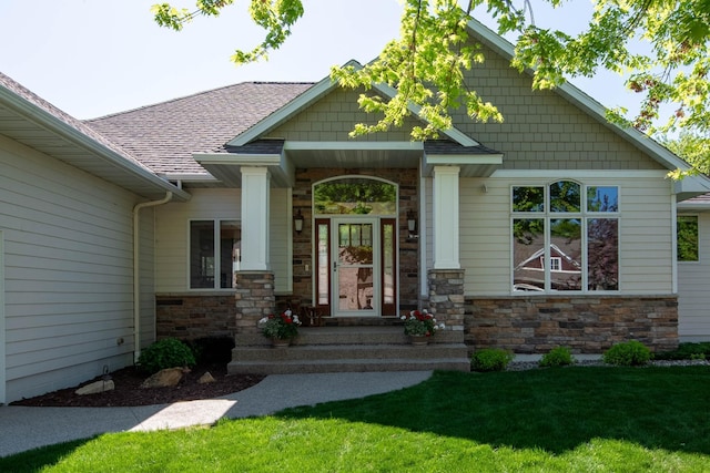 26 Deerwood Ct, North Mankato, MN 56003 - doorway to property with stone siding, a lawn, and a shingled roof