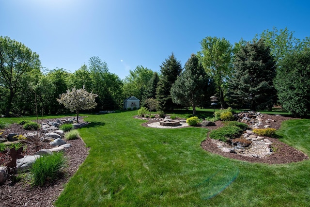 26 Deerwood Ct, North Mankato, MN 56003 - view of grassy yard featuring an outdoor fire pit, a shed, and an outdoor structure